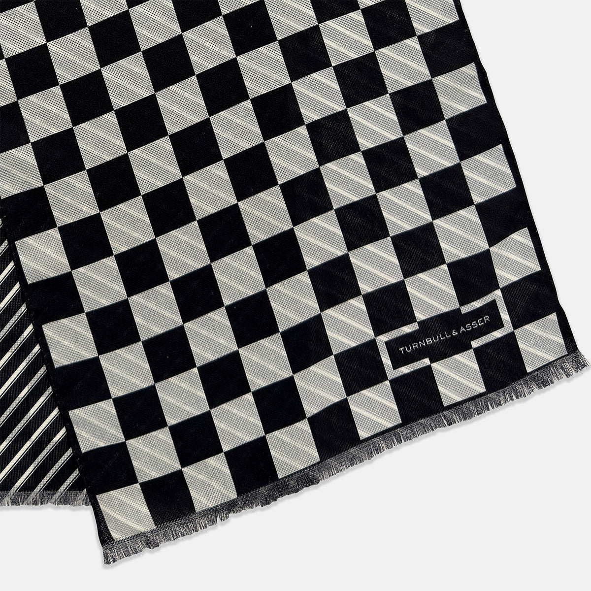 View 3 of product A Chequered Navy on Navy Frame Large Scarf in Silk by Turnbull & Asser UK, featuring a navy checkered design with striped detailing at the neck, is elegantly displayed against a plain white background—an accessory inspired by the enduring sophistication of British motoring, perfect for occasions such as the Concours of Elegance 2026.