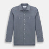 View 1 of product The Turnbull & Asser Steel Blue Piccadilly Shirt features long sleeves, a button-up front, two chest pockets, and white buttons, shown against a plain white background.