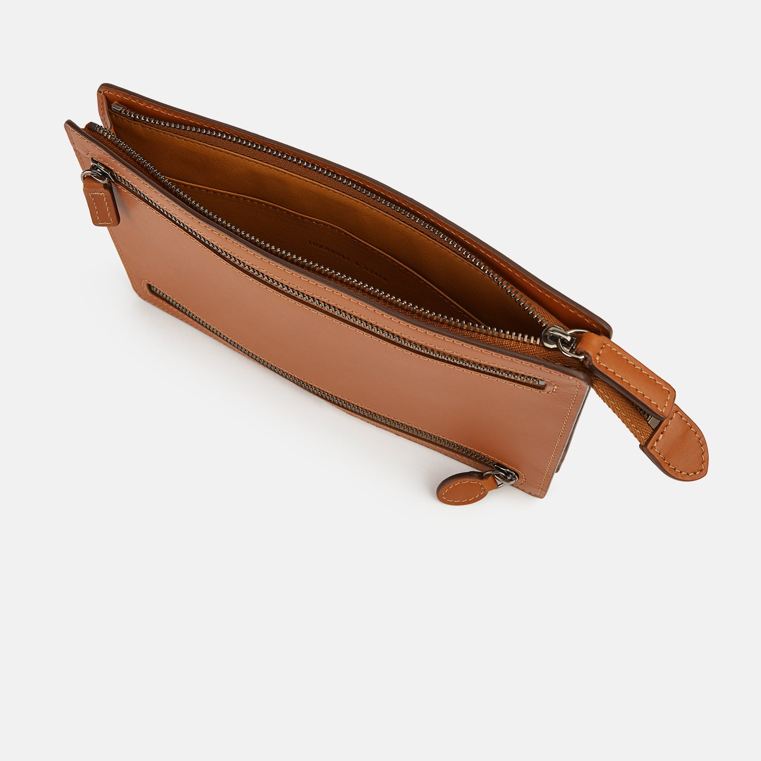 View 2 of product The Cognac Leather Zip Envelope Pouch by Turnbull & Asser UK features two horizontal zippered pockets, stitched edges, and leather pulls—offering a stylish way to organize essentials when you travel.