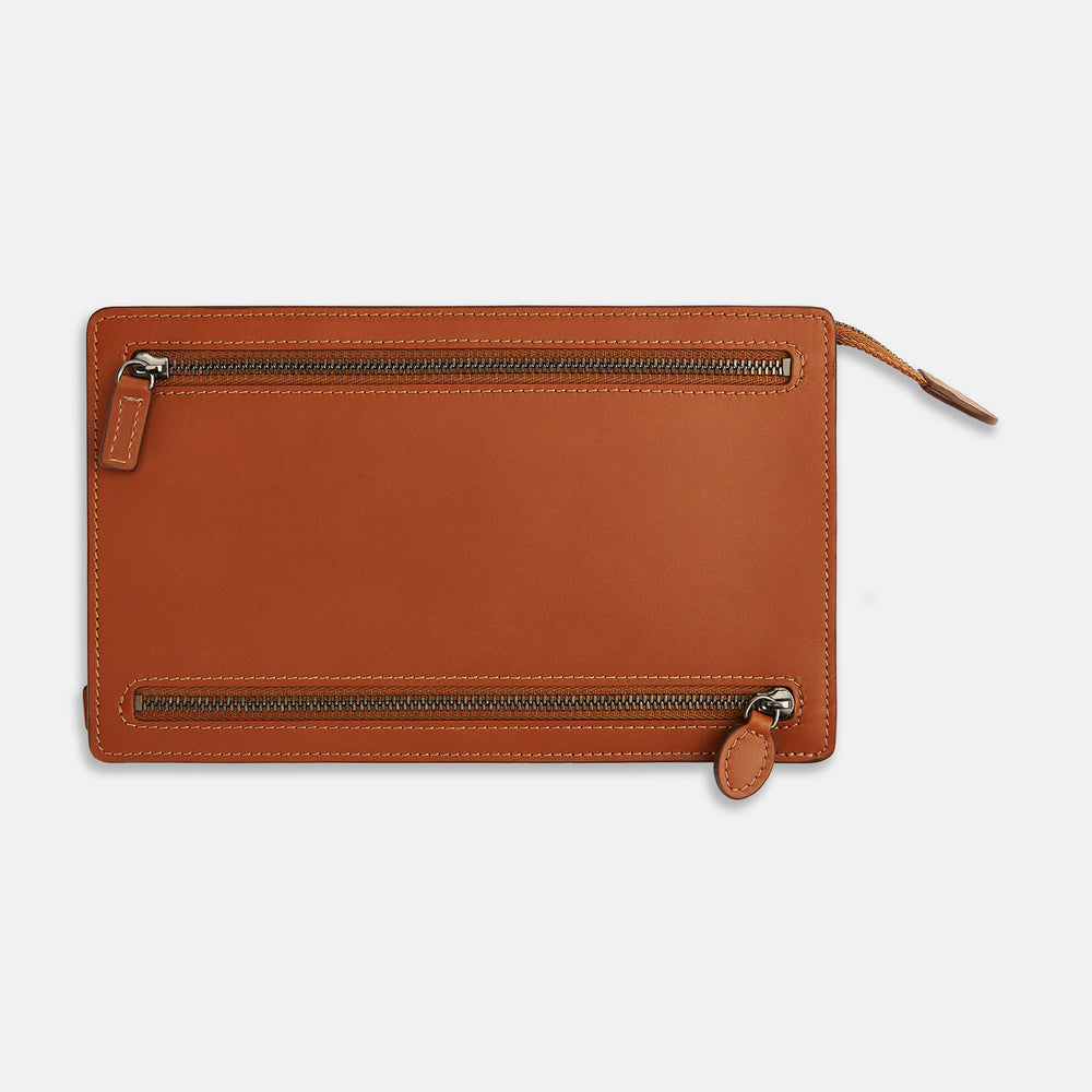 The Cognac Leather Zip Envelope Pouch by Turnbull & Asser UK features two horizontal zippered pockets, stitched edges, and leather pulls—offering a stylish way to organize essentials when you travel.