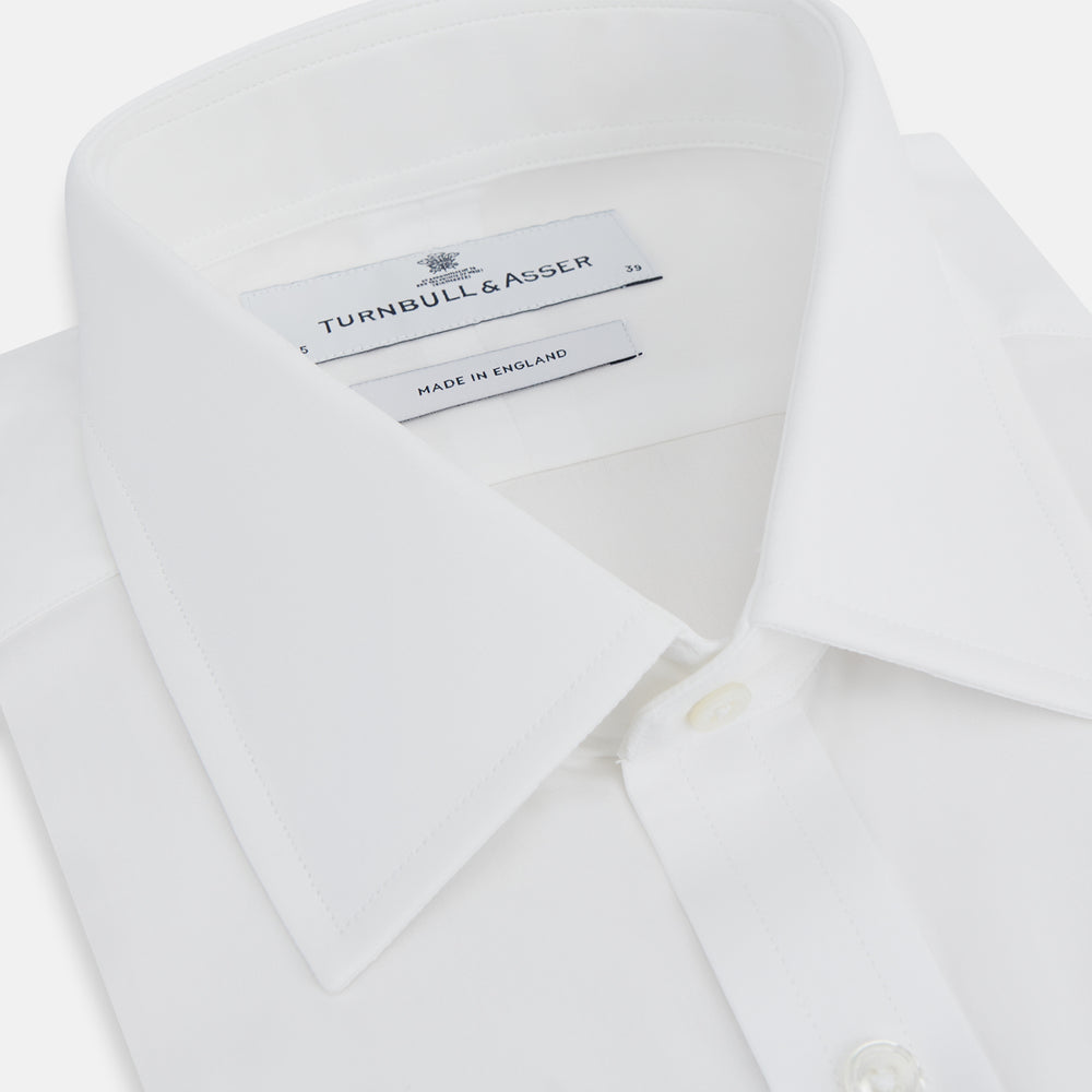 The Turnbull & Asser Plain White Cotton Shirt features a T&A collar, 3-button cuffs, and a timeless minimalist design, shown on a plain white background.