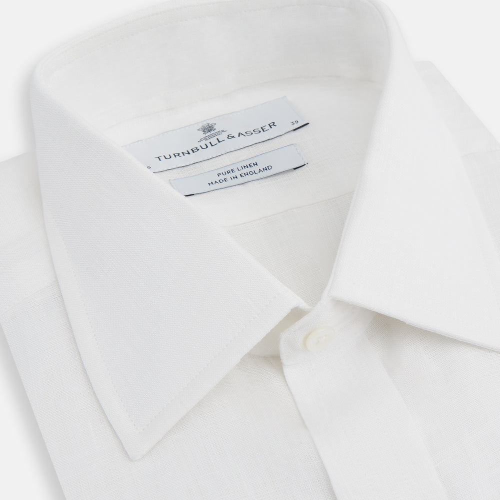 The Turnbull & Asser White Linen Shirt features a T&A collar and 3-button cuffs—an essential summer staple, shown here laid flat on a white background.
