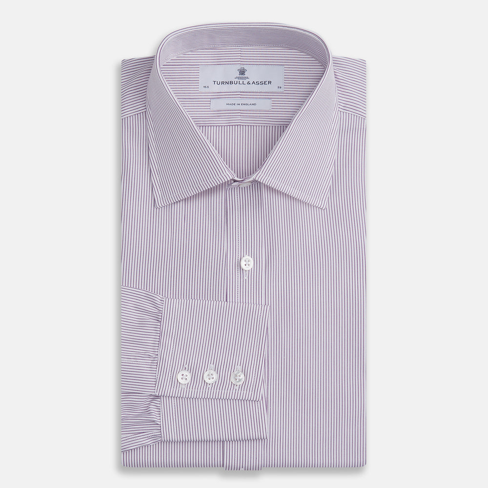 The Purple Pinstripe Mayfair Shirt by Turnbull & Asser is a light purple cotton poplin long-sleeve button-up with white stripes, a pointed collar, white buttons, and cuffed sleeves, shown laid flat on a white background.