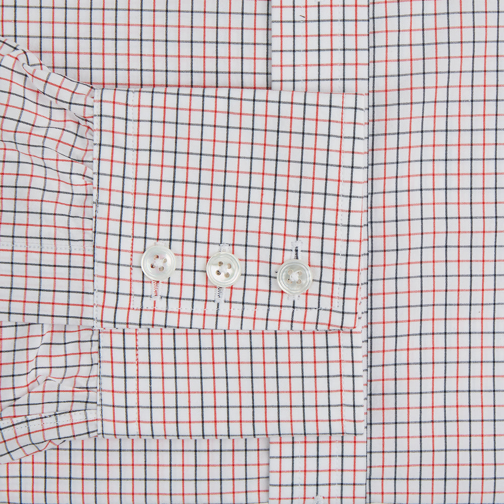 The Turnbull & Asser Red and Navy Graph Check Mayfair Shirt is a long-sleeved organic cotton button-up featuring a collar, buttoned cuffs, and a small red and navy check pattern, shown against a plain white background.