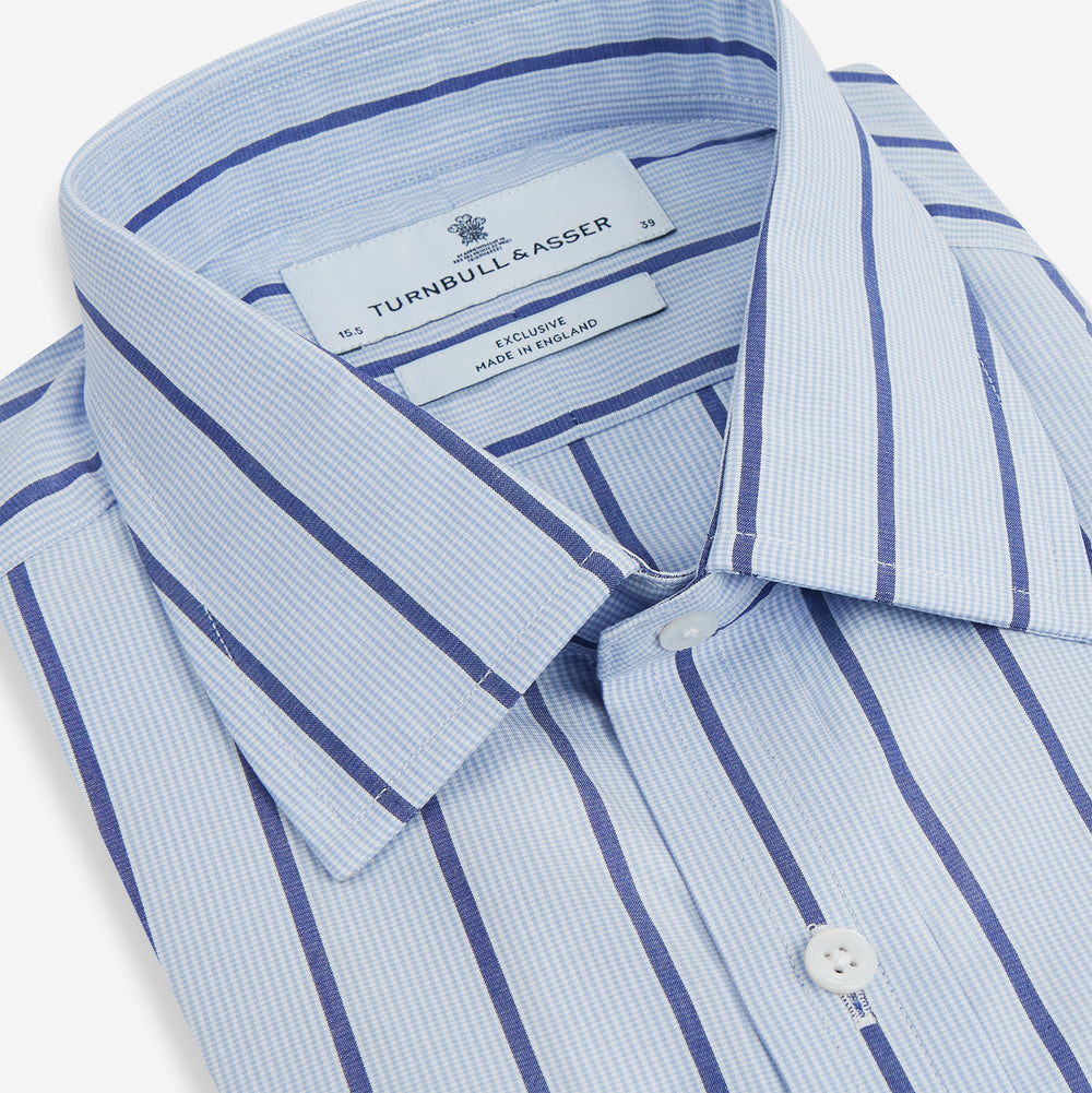 The Blue Track Stripe Mayfair Shirt by Turnbull & Asser features long sleeves, a T&A collar, vertical dark blue stripes on light blue organic cotton, and is shown against a plain white background.