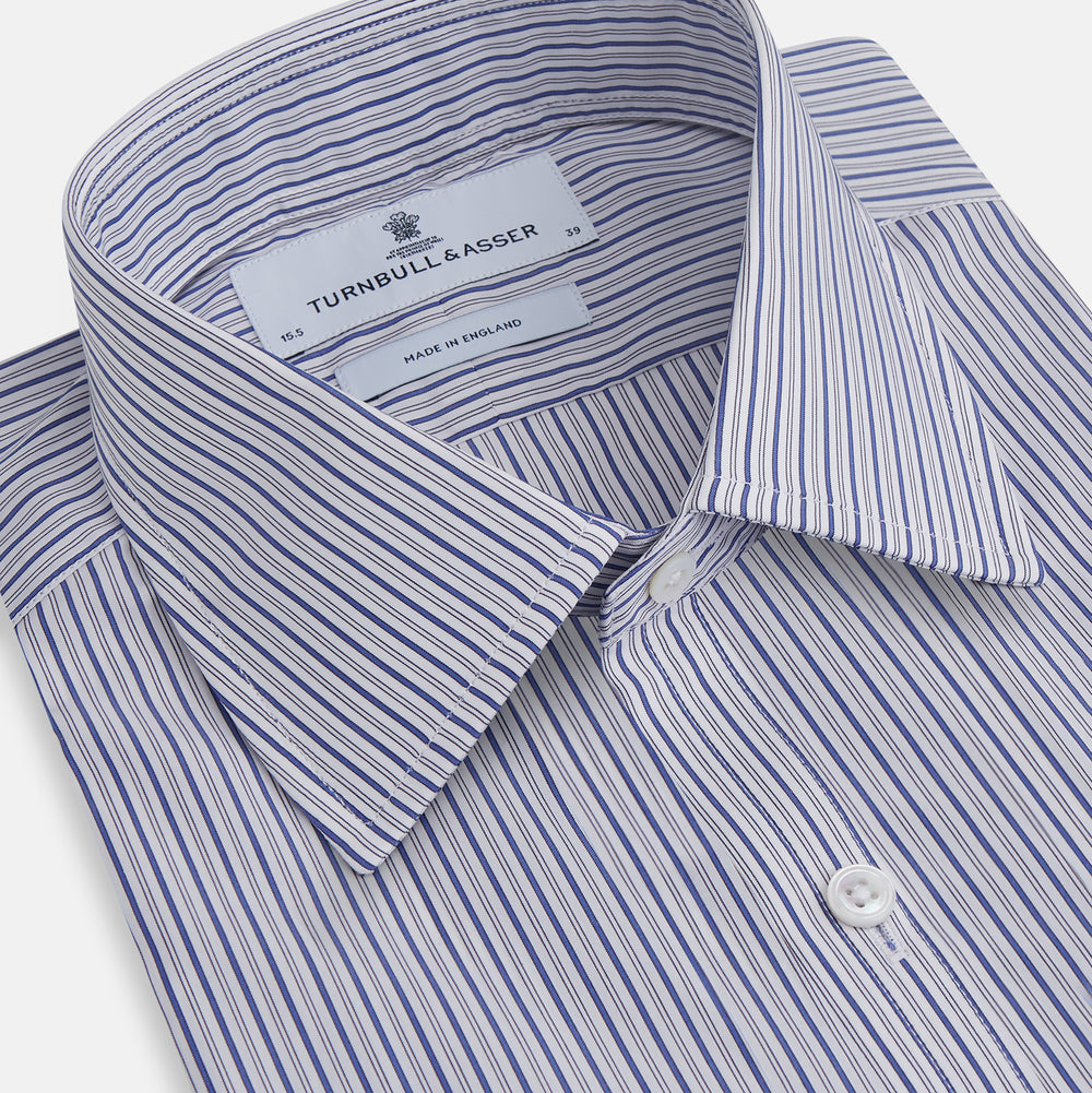 The Dark Blue Track Stripe Mayfair Shirt by Turnbull & Asser is a long-sleeve, button-up Egyptian cotton shirt with a classic collar and thin blue and white stripes, laid flat on a white background.