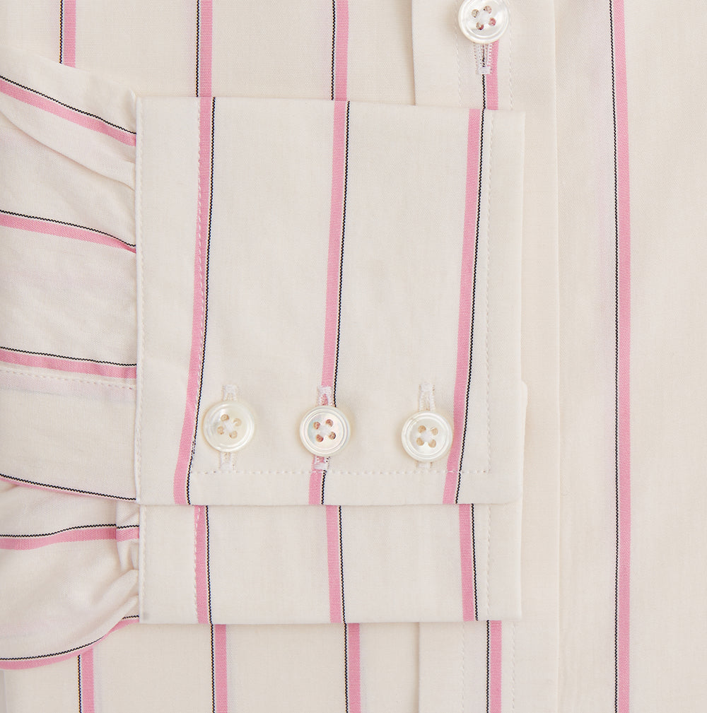 The Turnbull & Asser Pink Track Stripe Mayfair Shirt features long sleeves, a collar, and cream fabric with vertical pink stripes, crafted from breathable cotton and shown on a plain white background.