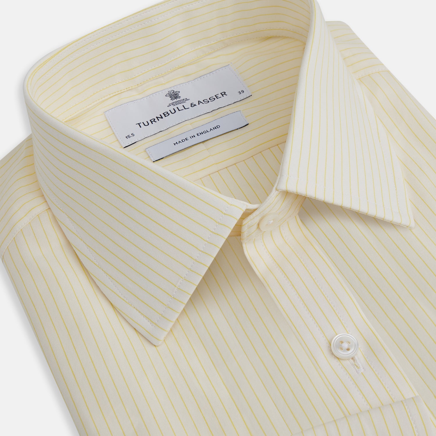 View 2 of product The Turnbull & Asser Yellow Pinstripe Mayfair Shirt, made from organic cotton with long sleeves, a T&A collar, and front buttons, features subtle vertical stripes and is shown on a plain white background.