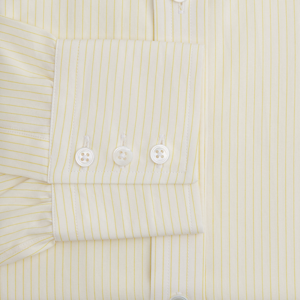 The Turnbull & Asser Yellow Pinstripe Mayfair Shirt, made from organic cotton with long sleeves, a T&A collar, and front buttons, features subtle vertical stripes and is shown on a plain white background.