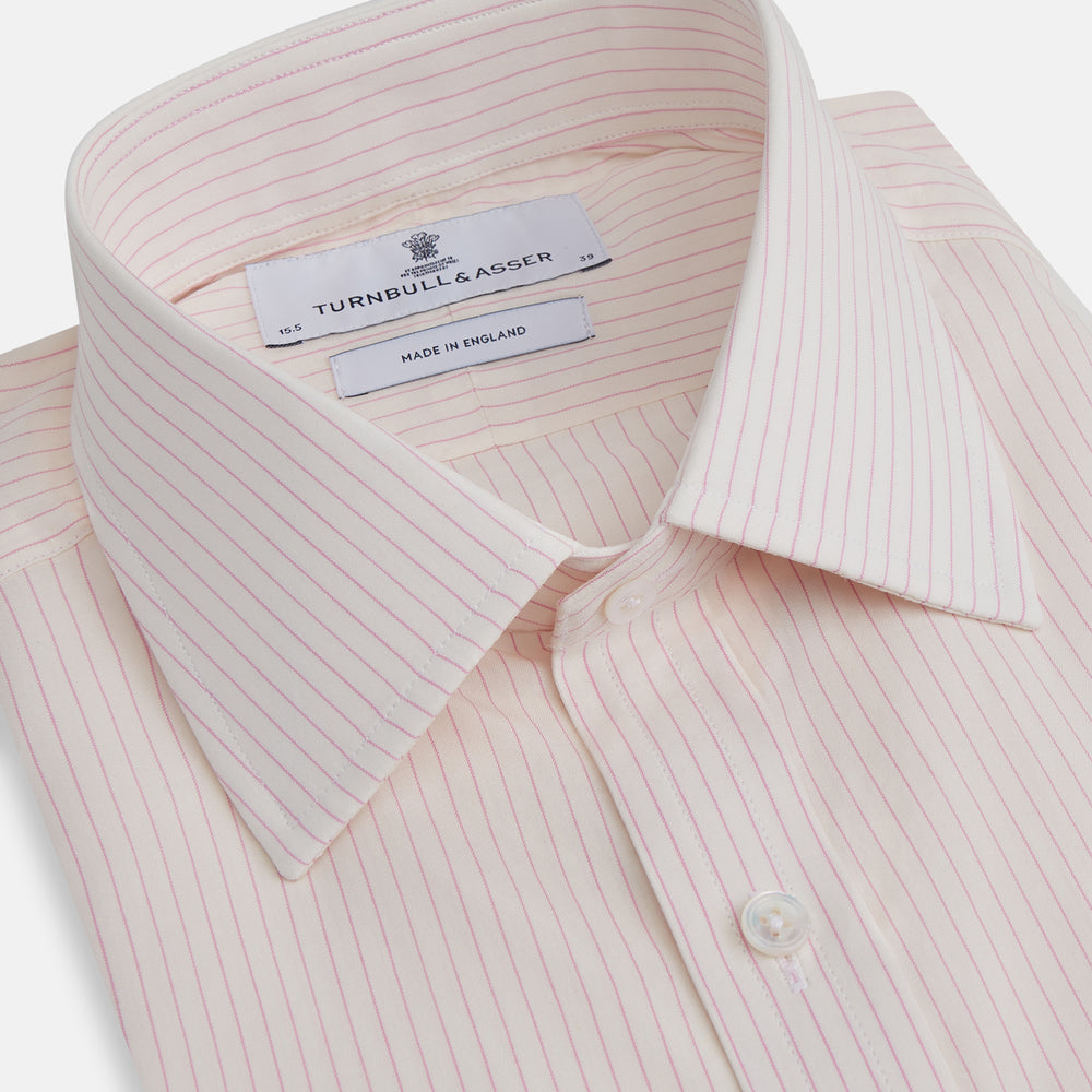 The Pink Pinstripe Mayfair Shirt by Turnbull & Asser is a long-sleeved, light pink organic cotton shirt with subtle pink pinstripes, classic collar, and buttoned cuffs, shown flat on a white background.