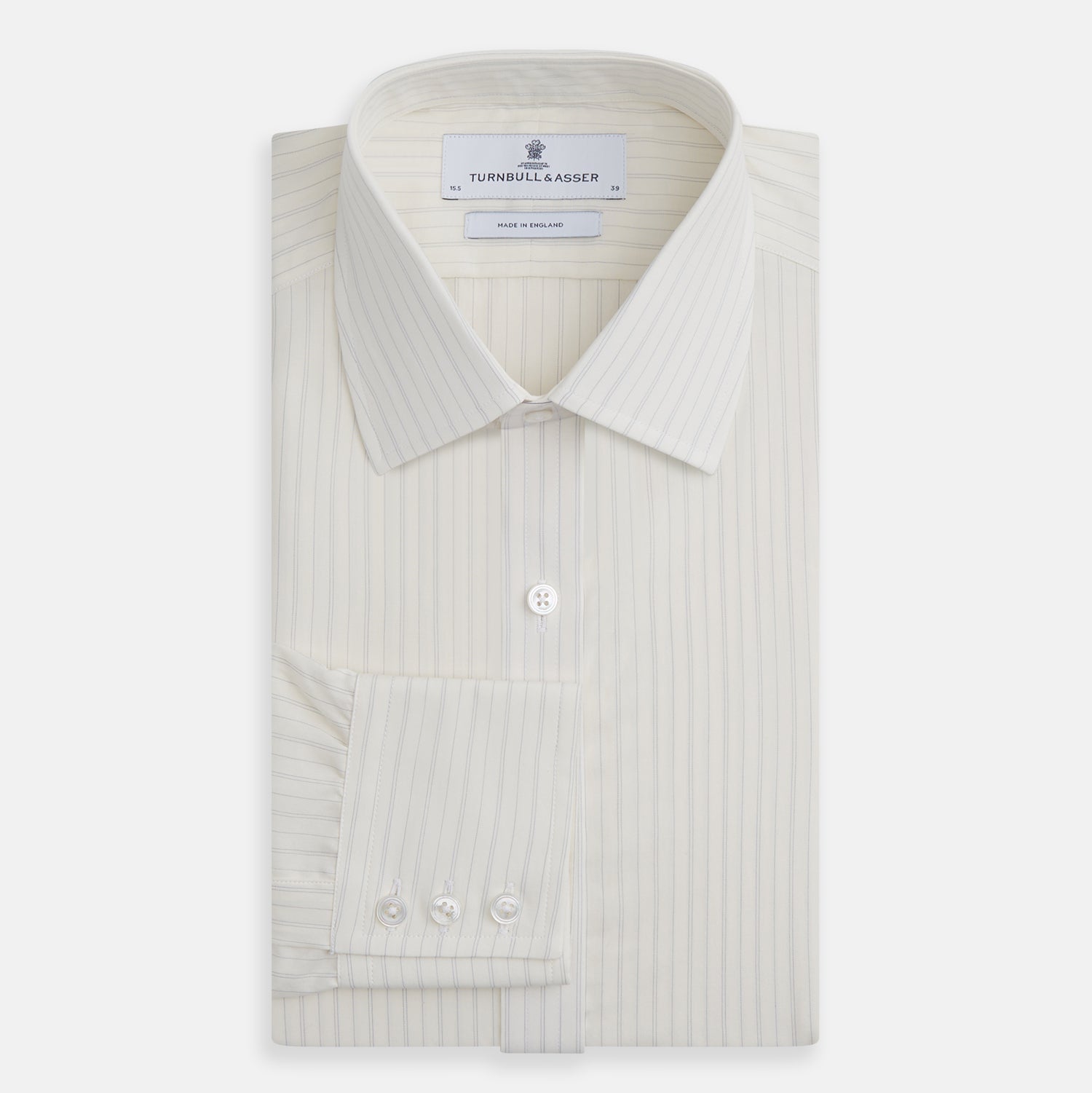 View 4 of product The Turnbull & Asser Pale Blue Fine Track Stripe Mayfair Shirt is a long-sleeve, cream-colored organic cotton shirt with subtle pale blue stripes, a T&A collar, and buttoned cuffs, shown on a plain white background.