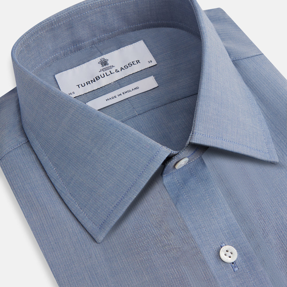 The Blue Mayfair Shirt by Turnbull & Asser is a long-sleeve, textured blue shirt with a classic T&A collar and white buttons, crafted from organic cotton and shown against a plain white background.