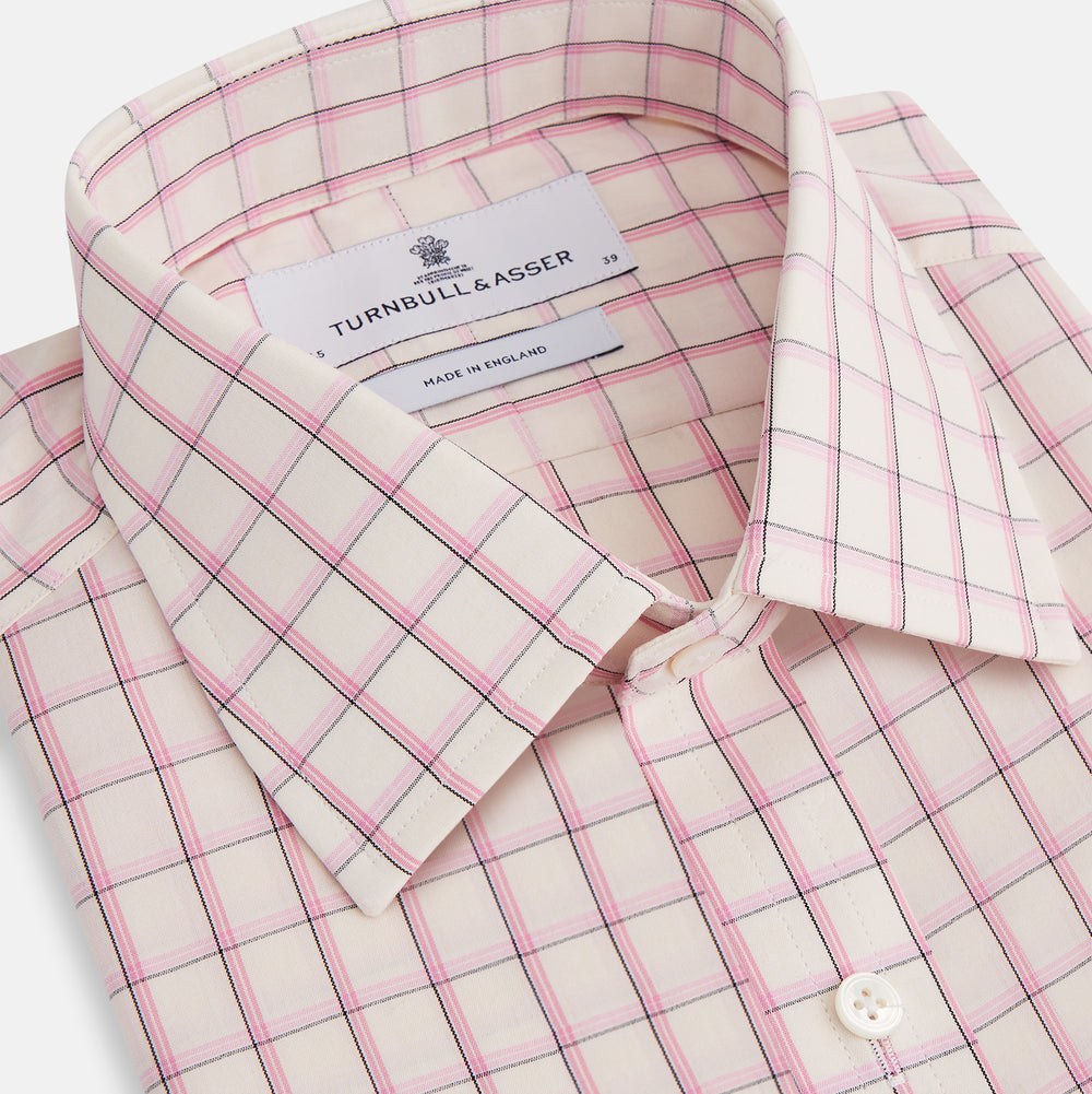 The Pink Shadow Check Mayfair Shirt by Turnbull & Asser is a long-sleeve, button-up cotton shirt with a collar, white base, and pink/red checks. It features buttoned cuffs and is shown neatly laid flat on a white background.