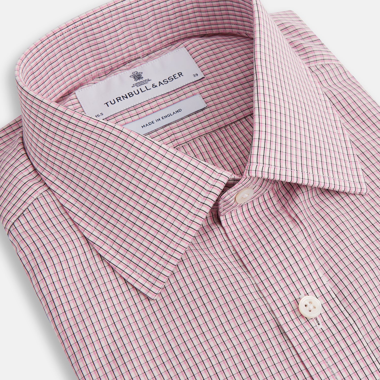 View 2 of product The Turnbull & Asser Pink Fine Graph Check Mayfair Shirt features long sleeves, breathable cotton, a pointed collar, 3-button cuffs, white buttons, and a red and white check pattern—shown on a plain white background.