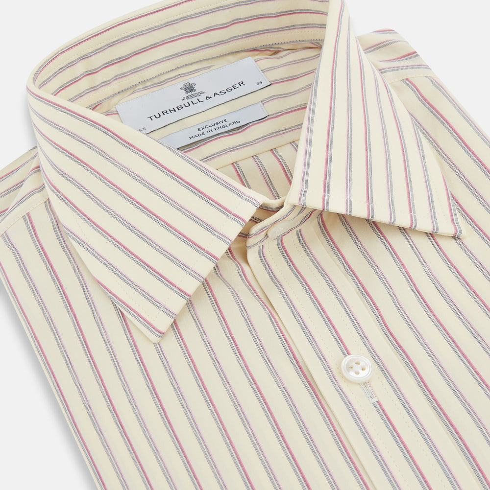 The Turnbull & Asser Pink Double Stripe Mayfair Shirt features long sleeves, a pointed T&A collar, and buttoned cuffs, crafted from organic cotton with pink double stripes on white, shown laid flat against a light background.