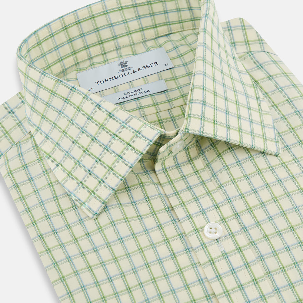 The Turnbull & Asser Green Multi Check Mayfair Shirt features a light green and white checkered pattern, long sleeves, a collar, and buttoned cuffs. Displayed on a white background.