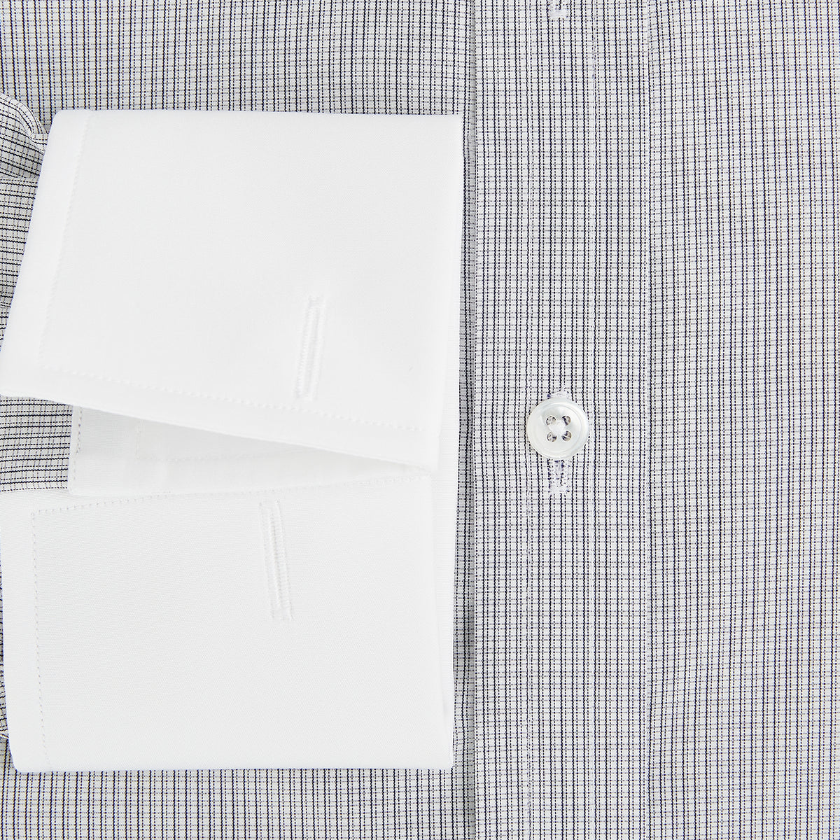 View 4 of product A Chequered White on Navy Regular Fit Shirt in Cotton by Turnbull & Asser UK, featuring a light gray finely checked pattern with a contrasting white collar and white French cuffs, long sleeves, buttoned up and displayed against a white background.