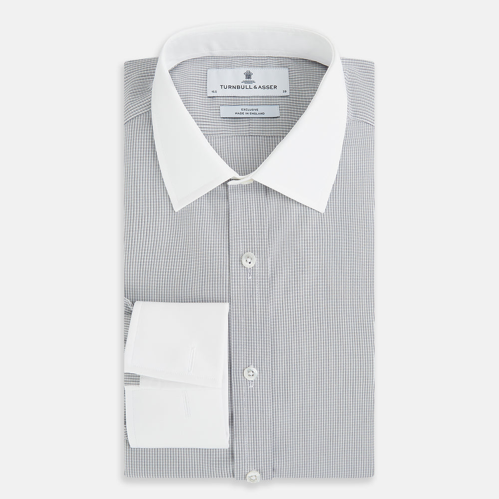 A Chequered White on Navy Regular Fit Shirt in Cotton by Turnbull & Asser UK, featuring a light gray finely checked pattern with a contrasting white collar and white French cuffs, long sleeves, buttoned up and displayed against a white background.