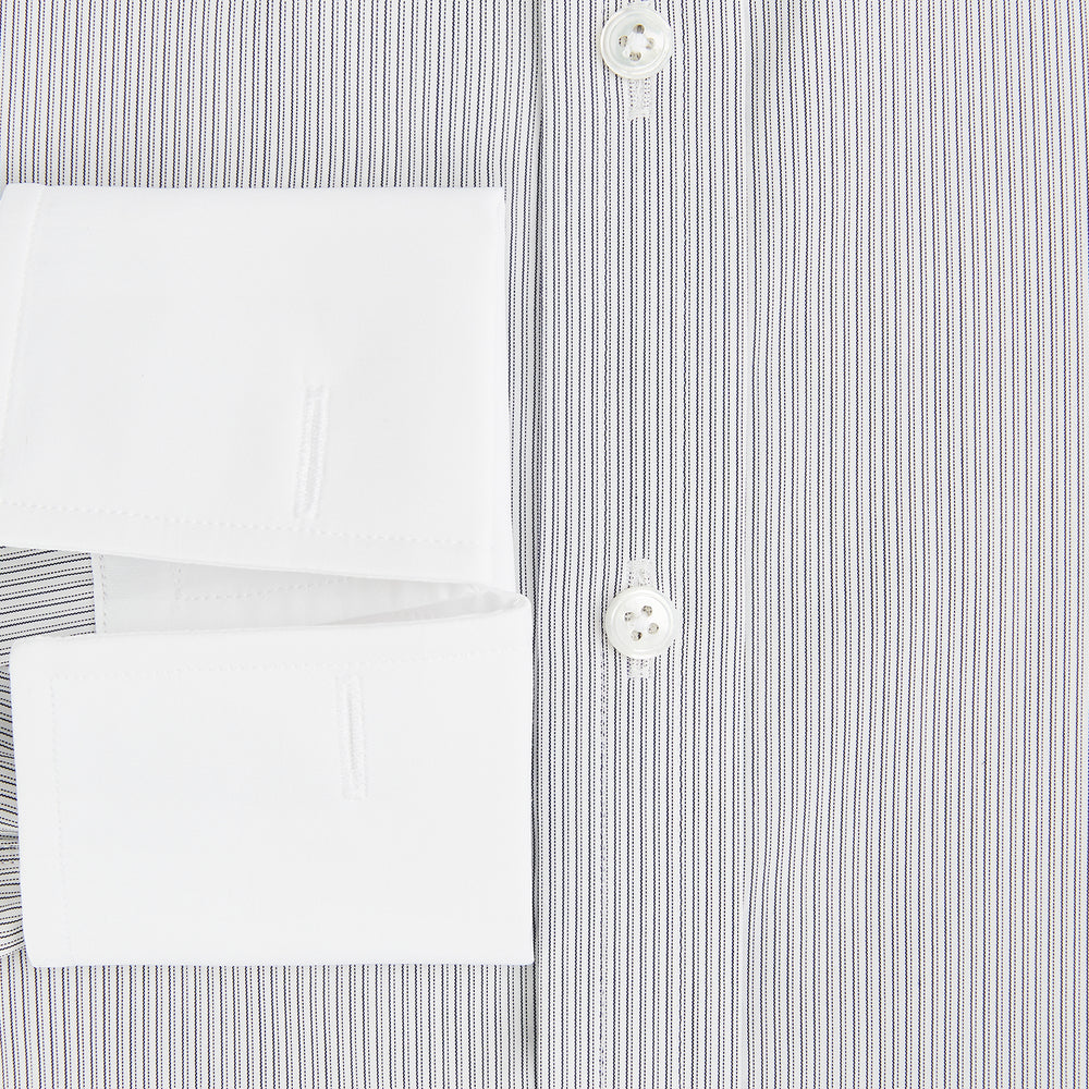 A navy men’s dress shirt with subtle white stripes, crafted from cotton and laid flat on a plain white background; the Striped White on Navy Regular Fit Shirt by Turnbull & Asser UK is a timeless formal piece for any wardrobe.