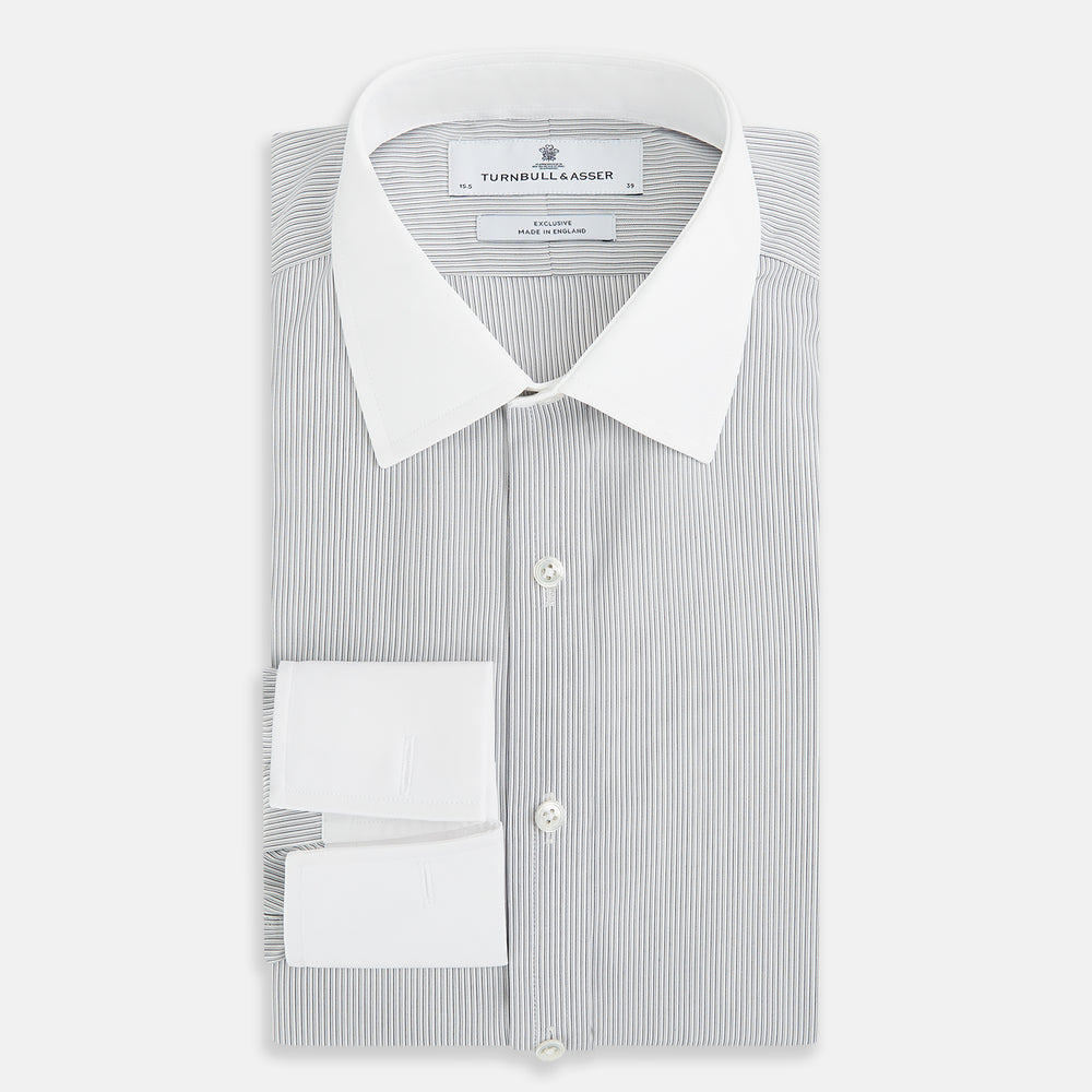 A navy men’s dress shirt with subtle white stripes, crafted from cotton and laid flat on a plain white background; the Striped White on Navy Regular Fit Shirt by Turnbull & Asser UK is a timeless formal piece for any wardrobe.