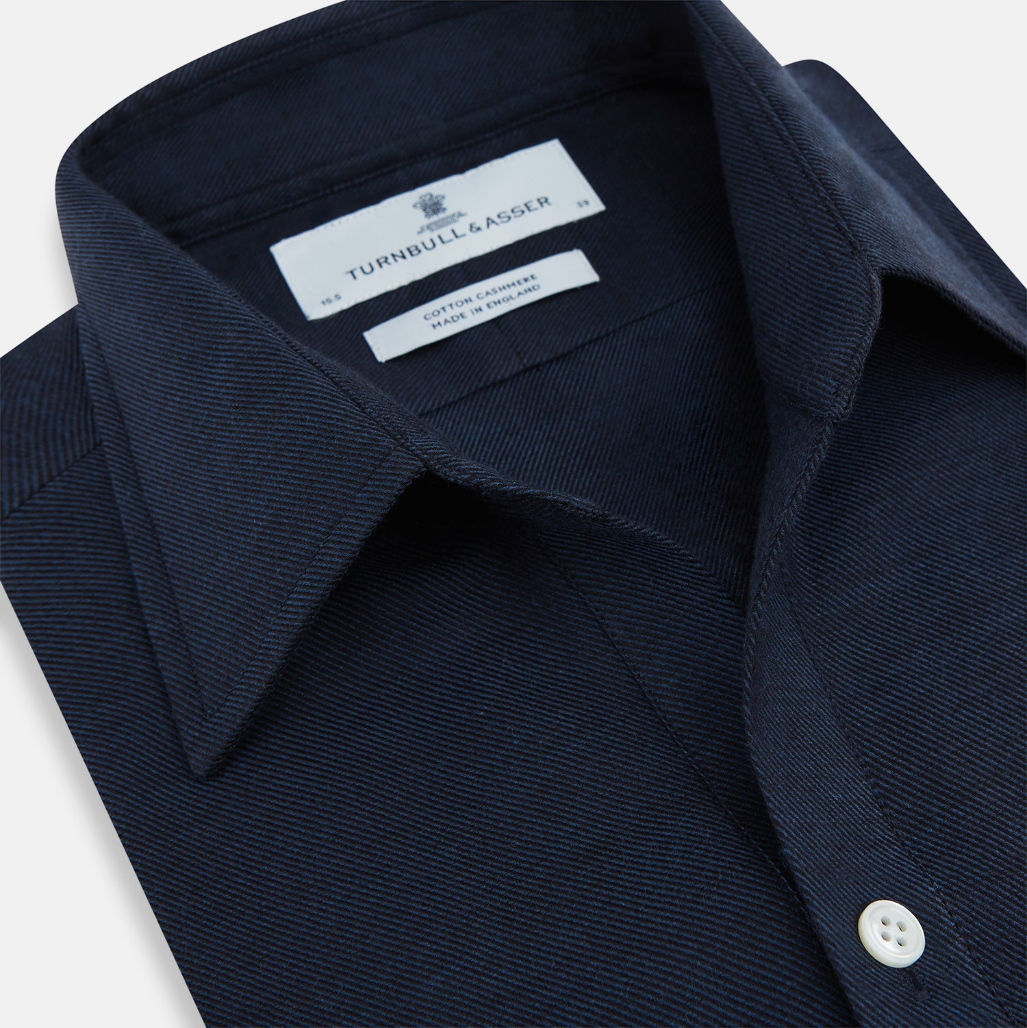 View 2 of product The Turnbull & Asser Navy Cotton Cashmere Chelsea Shirt features long sleeves, a classic collar, front chest pocket, and white buttons, shown laid flat on a white background.
