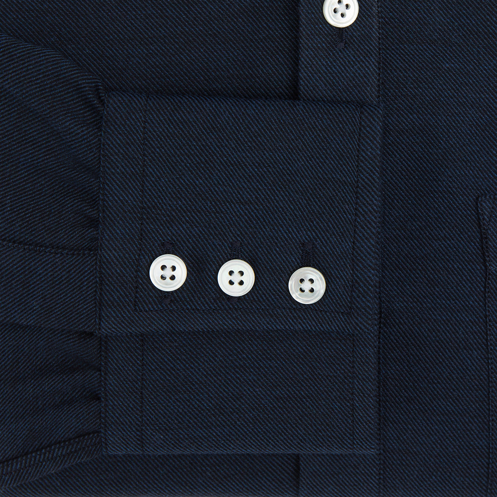 The Turnbull & Asser Navy Cotton Cashmere Chelsea Shirt features long sleeves, a classic collar, front chest pocket, and white buttons, shown laid flat on a white background.