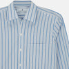 View 4 of product The Turnbull & Asser Blue Multi Track Stripe Chelsea Shirt features long sleeves, a light blue multi-stripe design, a chest pocket, open collar, and buttoned cuffs, shown laid flat on a white background.