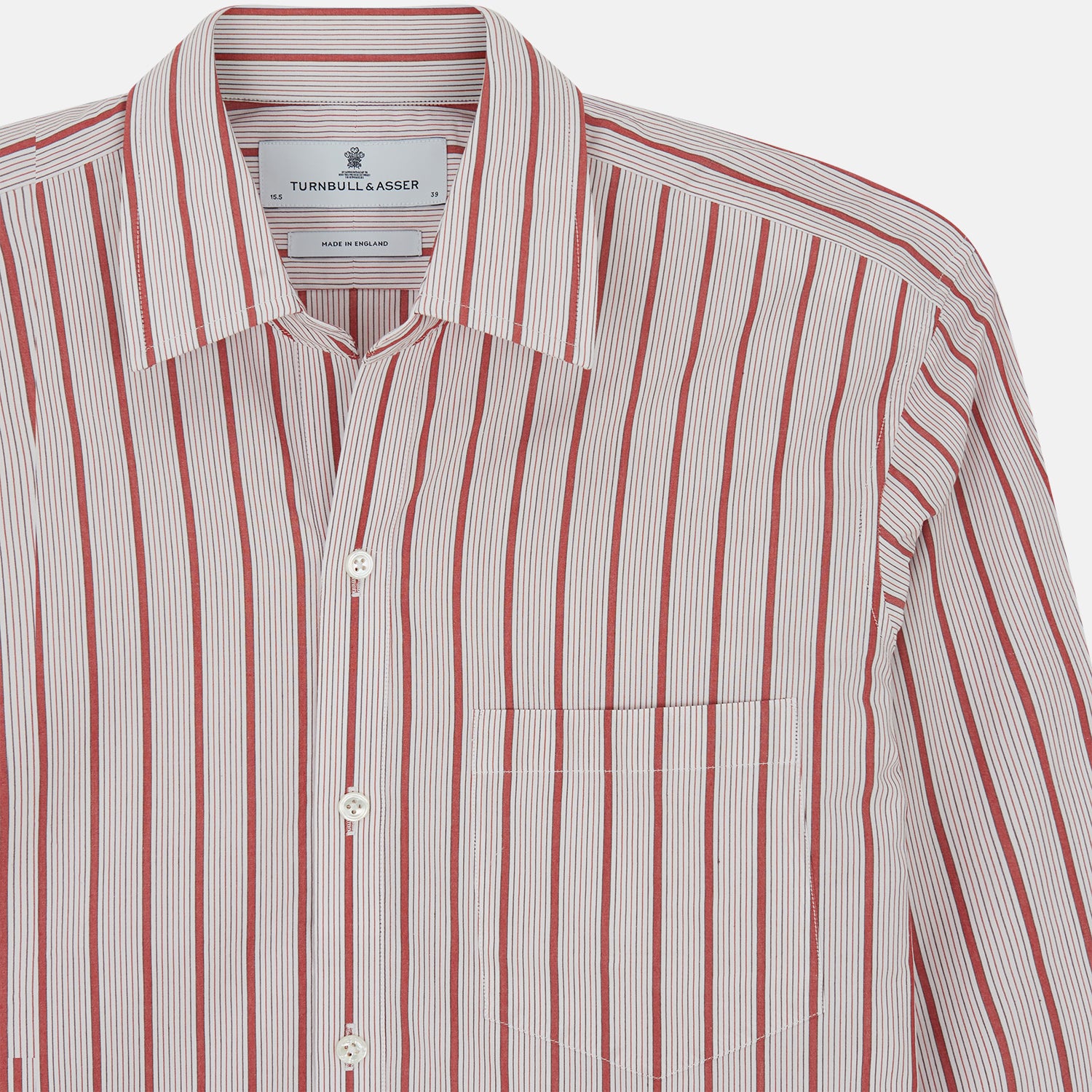 View 4 of product The Turnbull & Asser Red Multi Track Stripe Chelsea Shirt features a classic open collar, long sleeves, red vertical stripes on white, and a left chest pocket—laid flat against a plain background.