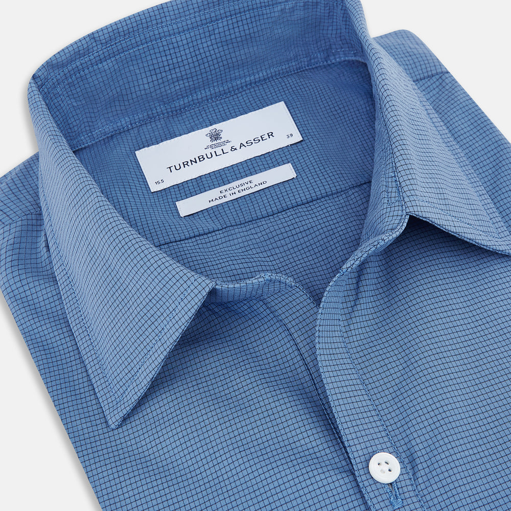 A Colony Blue Pin Check Windsor Shirt by Turnbull & Asser UK, featuring long sleeves, white buttons, a classic Turnbull collar, and buttoned cuffs—expertly crafted in Britain and displayed flat on a white background.