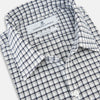 View 2 of product The Chequered Navy on White Windsor Regular Fit Shirt in Cotton by Turnbull & Asser UK features a Windsor collar and long sleeves, showcasing a crisp white background with a navy grid check pattern, displayed on a plain white surface.