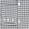 View 4 of product The Chequered Navy on White Windsor Regular Fit Shirt in Cotton by Turnbull & Asser UK features a Windsor collar and long sleeves, showcasing a crisp white background with a navy grid check pattern, displayed on a plain white surface.