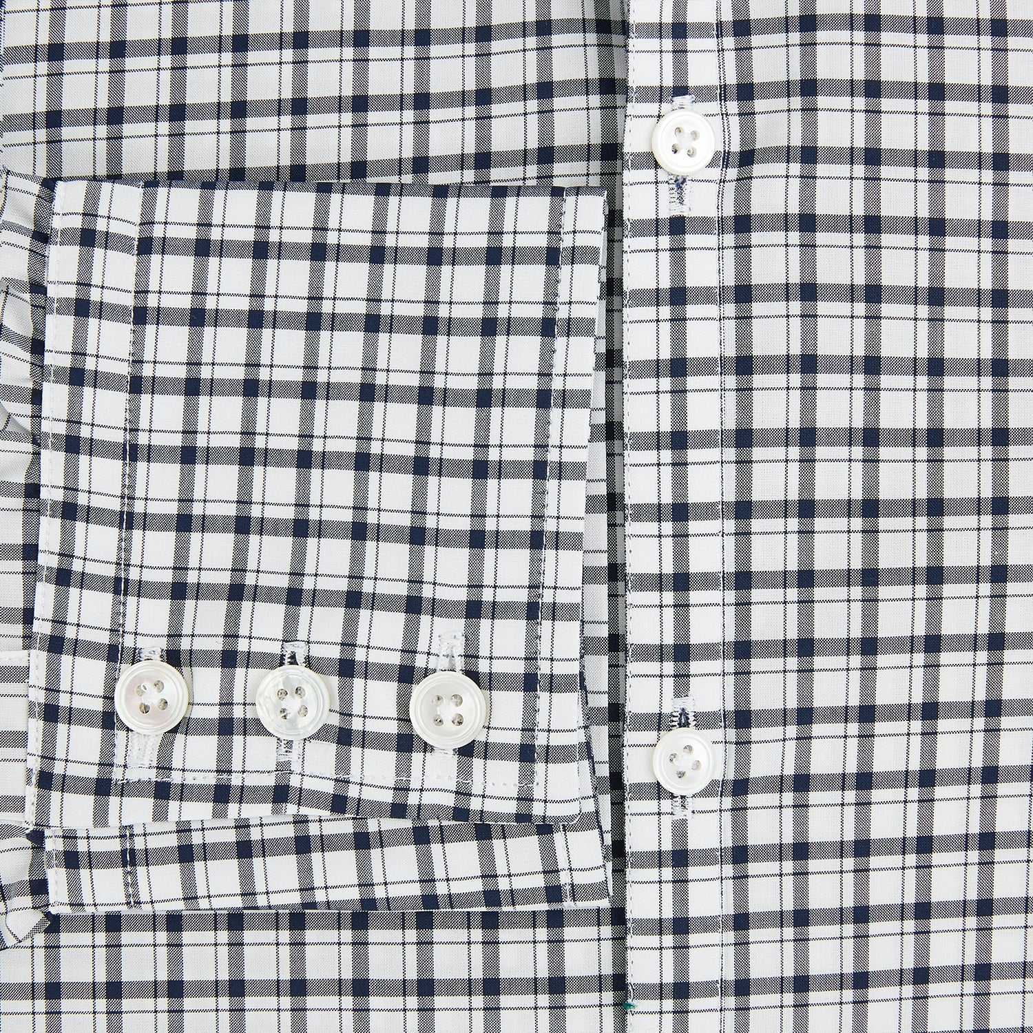 View 4 of product The Chequered Navy on White Windsor Regular Fit Shirt in Cotton by Turnbull & Asser UK features a Windsor collar and long sleeves, showcasing a crisp white background with a navy grid check pattern, displayed on a plain white surface.