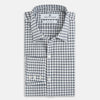 View 5 of product The Chequered Navy on White Windsor Regular Fit Shirt in Cotton by Turnbull & Asser UK features a Windsor collar and long sleeves, showcasing a crisp white background with a navy grid check pattern, displayed on a plain white surface.