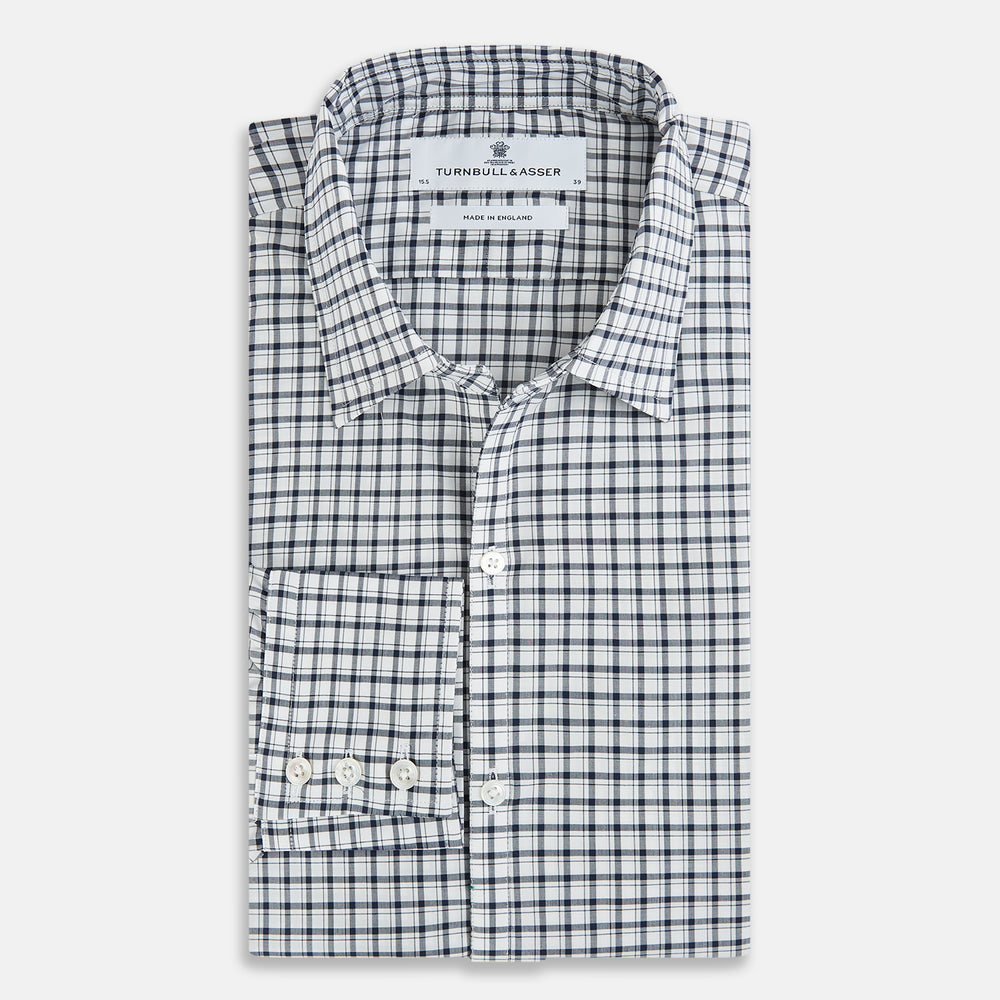 The Chequered Navy on White Windsor Regular Fit Shirt in Cotton by Turnbull & Asser UK features a Windsor collar and long sleeves, showcasing a crisp white background with a navy grid check pattern, displayed on a plain white surface.