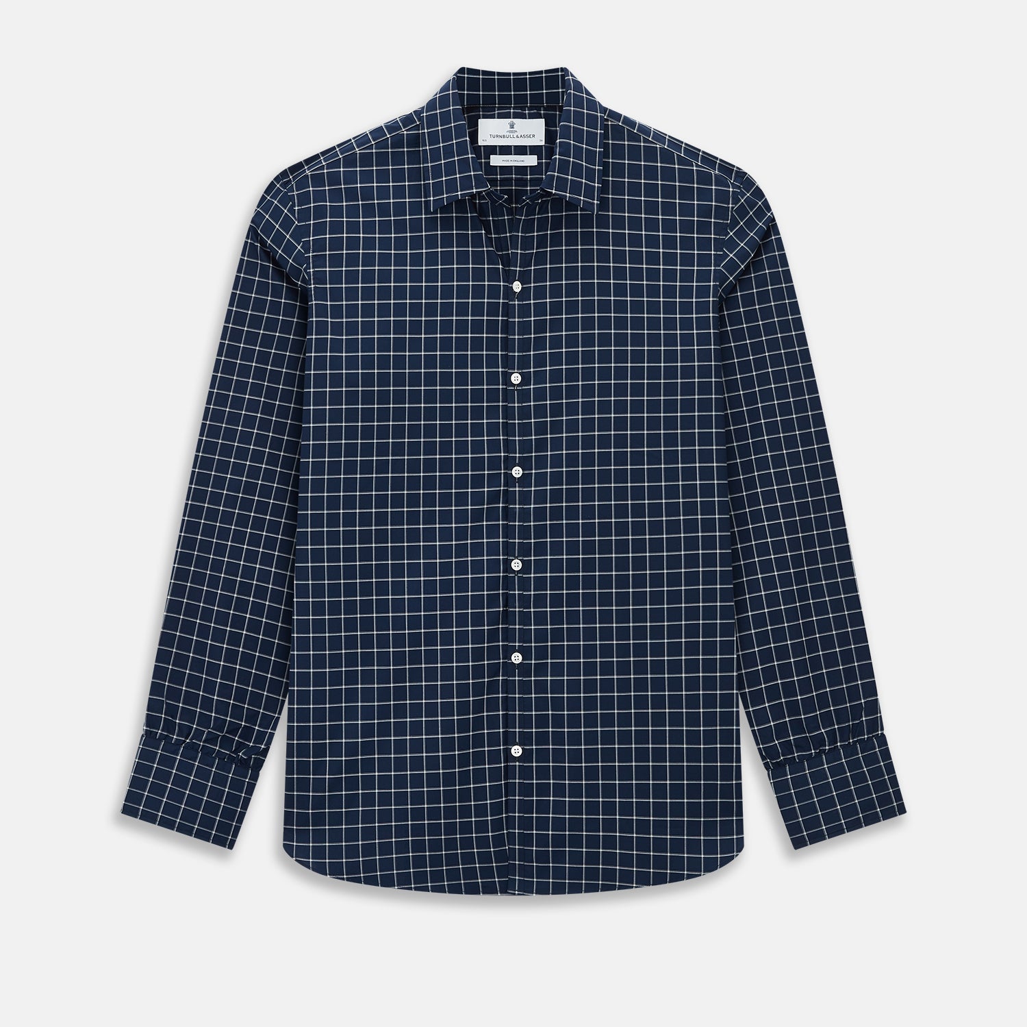 View 1 of product The Turnbull & Asser UK White Check on Navy Windsor Shirt features an open collar, button cuffs, and cuffed long sleeves. Showcased against a white background, this shirt presents a navy base adorned with a white grid pattern.
