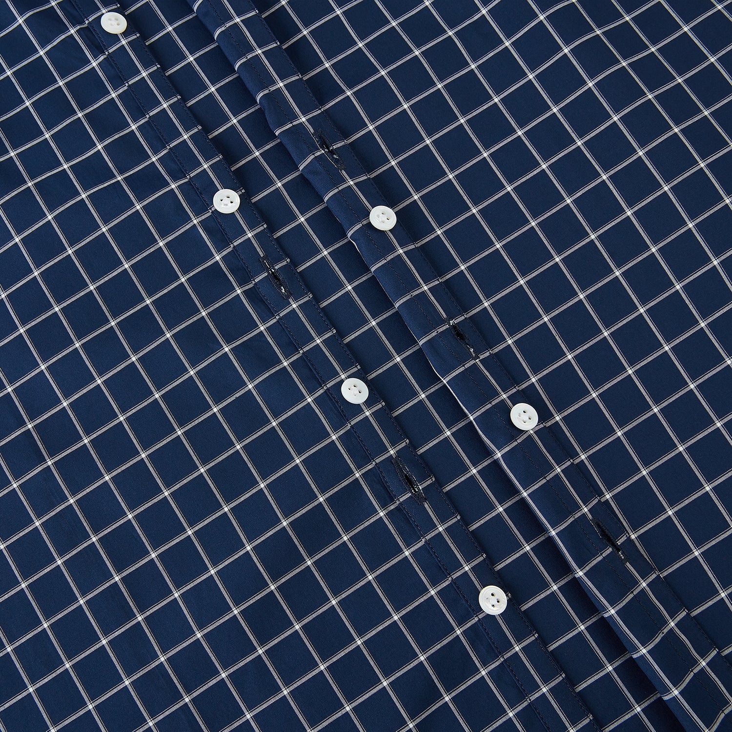 View 7 of product The Turnbull & Asser UK White Check on Navy Windsor Shirt features an open collar, button cuffs, and cuffed long sleeves. Showcased against a white background, this shirt presents a navy base adorned with a white grid pattern.