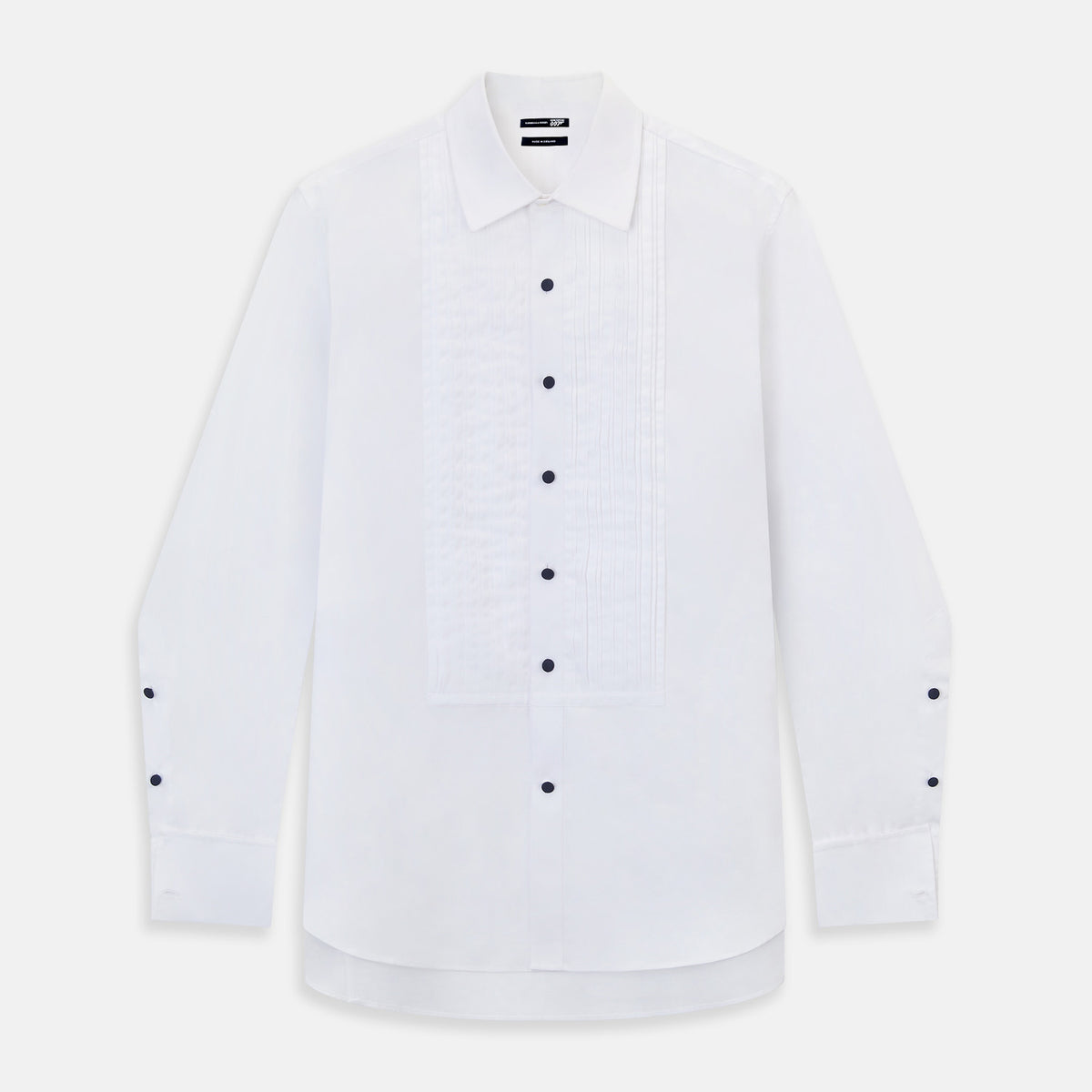View 11 of product The Casino Royale White Dress Shirt in Cotton by Turnbull & Asser UK is a long-sleeve white dress shirt, crafted from crisp white cotton poplin with a pleated bib front, black buttons, and a classic collar, shown laid flat on a white background.