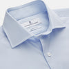 View 2 of product The Turnbull & Asser Tailored Fit Light Blue Cotton Shirt features a Kent collar, buttoned front, and 3-button cuffs, ideal for pairing with a navy suit and shown laid flat on a white background.