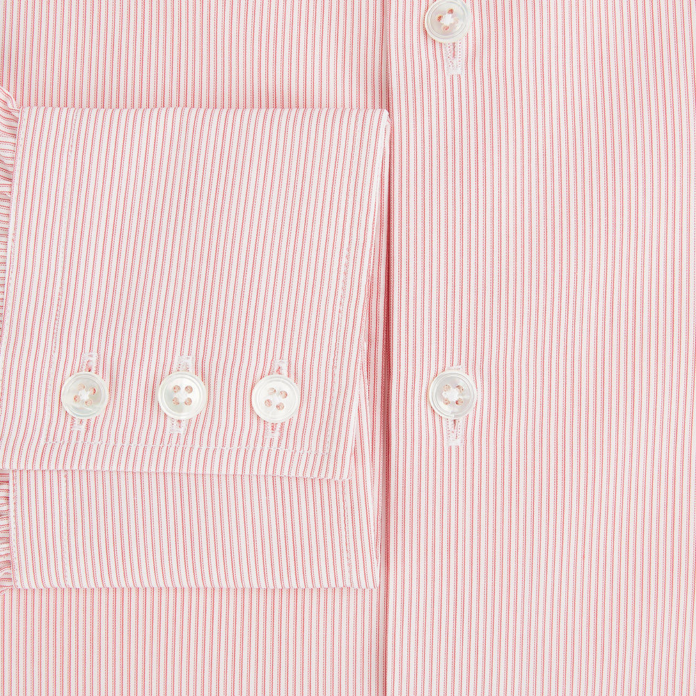 The Fine Striped Coral on White Tailored Fit Shirt in Cotton by Turnbull & Asser UK is a light pink long-sleeve button-up dress shirt with a collar, featuring subtle coral stripe detailing, displayed flat against a white background.