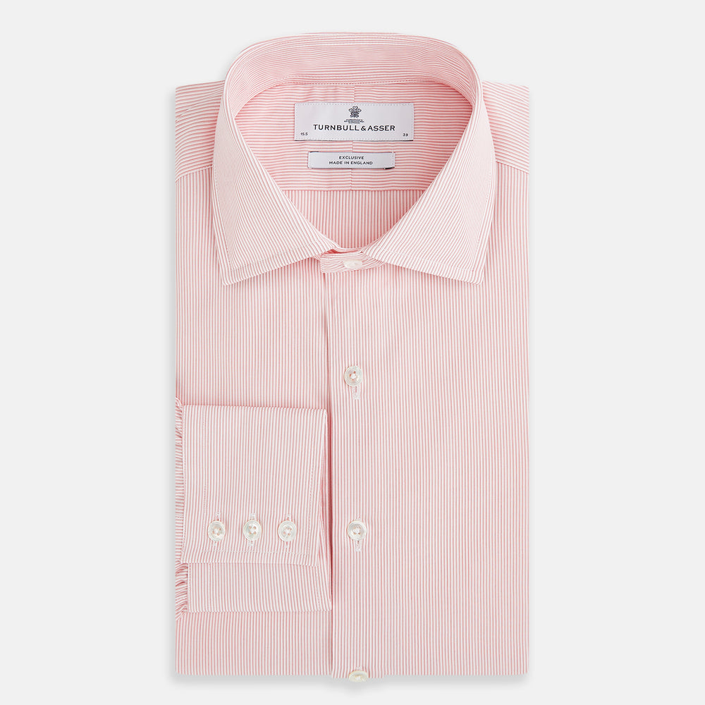 The Fine Striped Coral on White Tailored Fit Shirt in Cotton by Turnbull & Asser UK is a light pink long-sleeve button-up dress shirt with a collar, featuring subtle coral stripe detailing, displayed flat against a white background.
