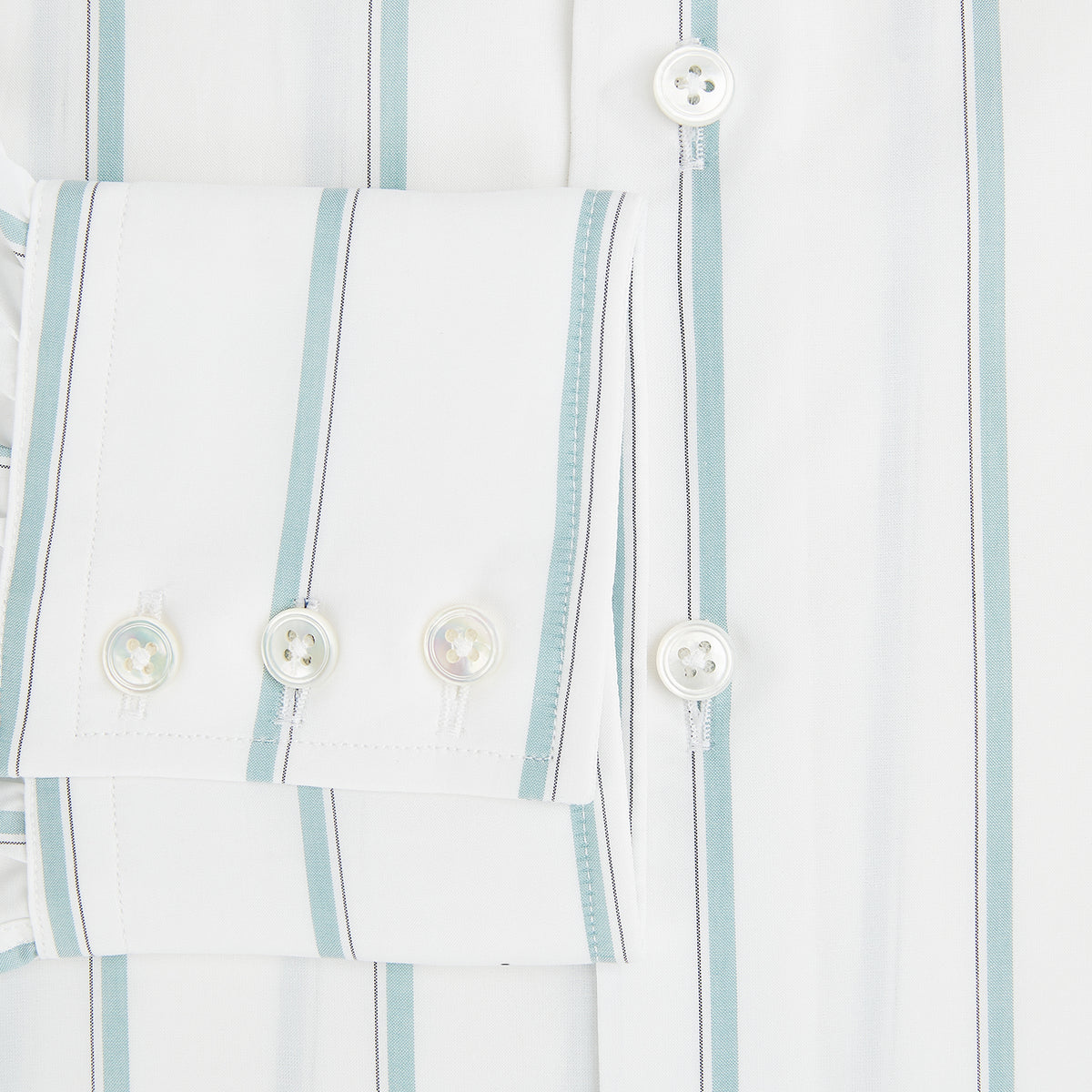 View 4 of product Track Striped Sage on White Tailored Fit Shirt in Cotton by Turnbull & Asser UK, featuring light blue vertical stripes, a classic collar, and cuffed long sleeves, displayed laid flat against a plain white background.