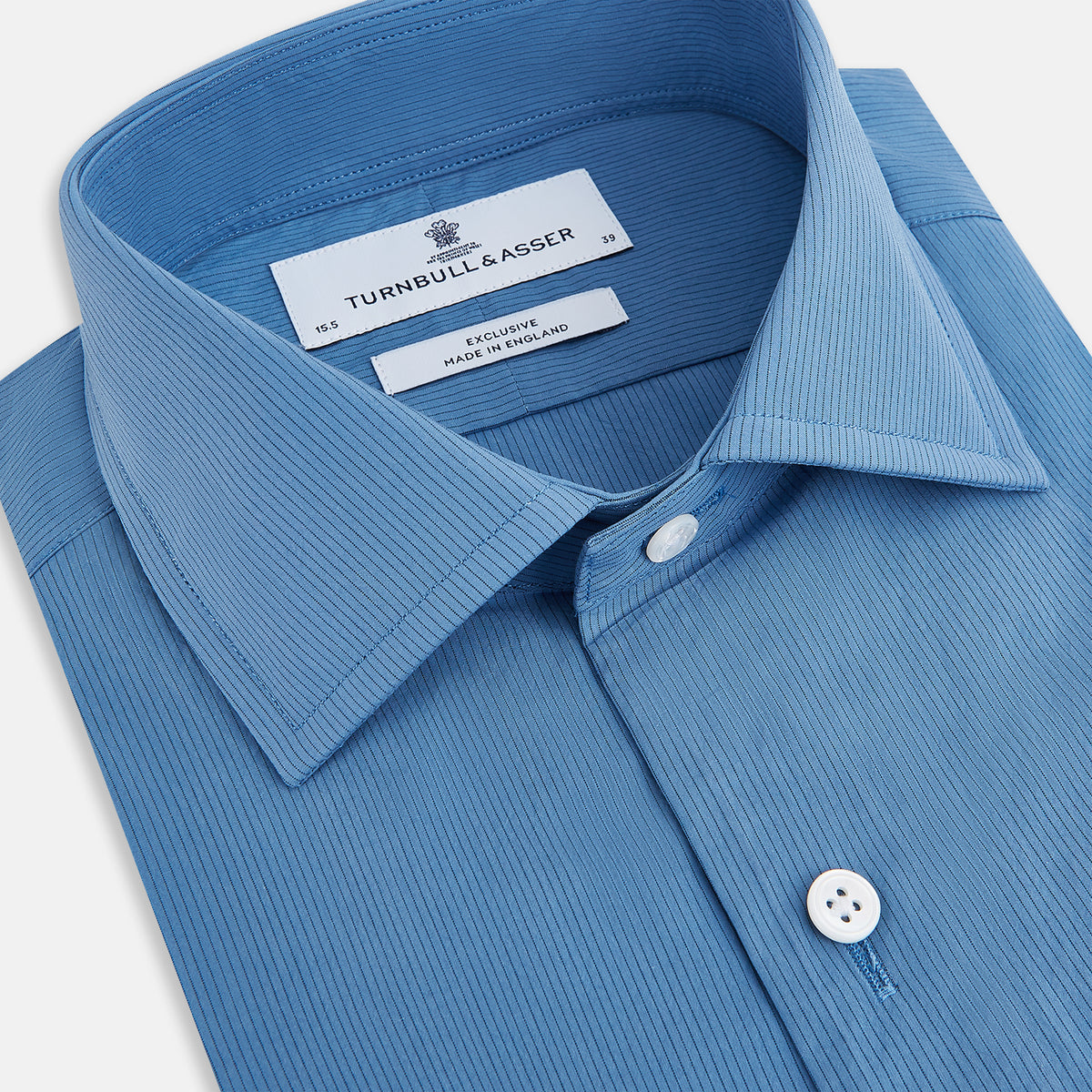 View 2 of product The Turnbull & Asser UK SHIRTS NEW TF KENT CLR 3BC COLONY BLUE/NAVY STRIPE is a long-sleeve button-up dress shirt featuring a pointed Kent collar, white buttons, and buttoned cuffs, shown against a plain white background.