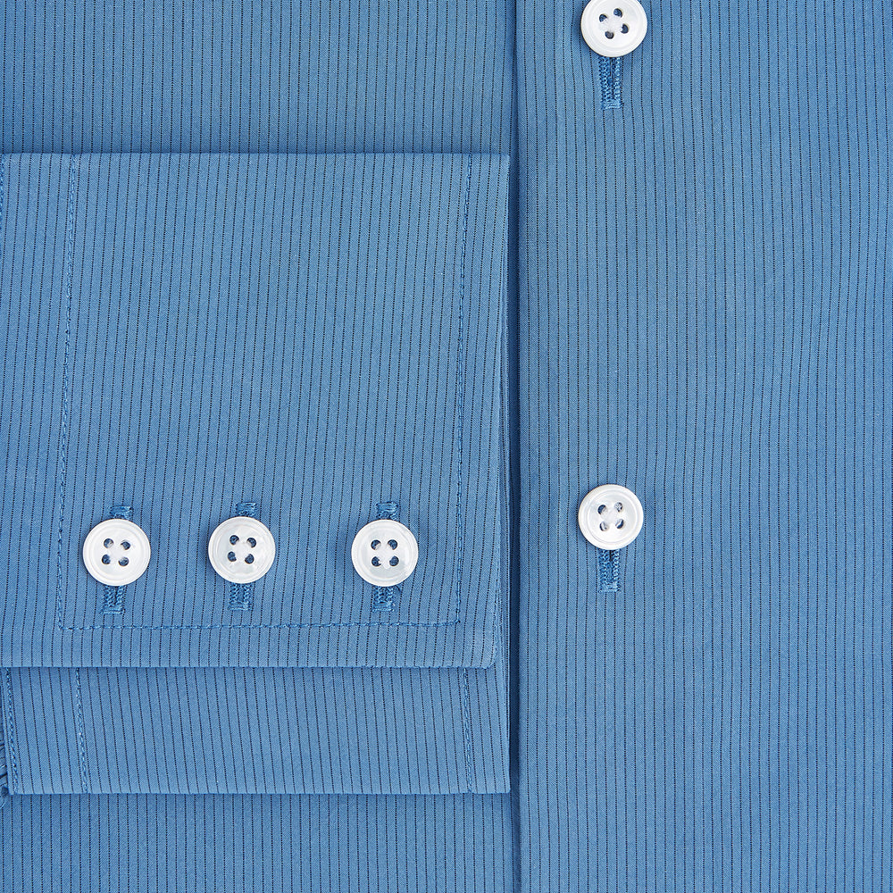 The Turnbull & Asser UK SHIRTS NEW TF KENT CLR 3BC COLONY BLUE/NAVY STRIPE is a long-sleeve button-up dress shirt featuring a pointed Kent collar, white buttons, and buttoned cuffs, shown against a plain white background.