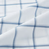 View 6 of product Large Checked Grey on White Weekend Fit Shirt in Cotton by Turnbull & Asser UK, featuring a white long-sleeve button-up design with a grey windowpane check pattern, front chest pocket, pointed derby collar, and buttoned cuffs, displayed flat on a plain white background.