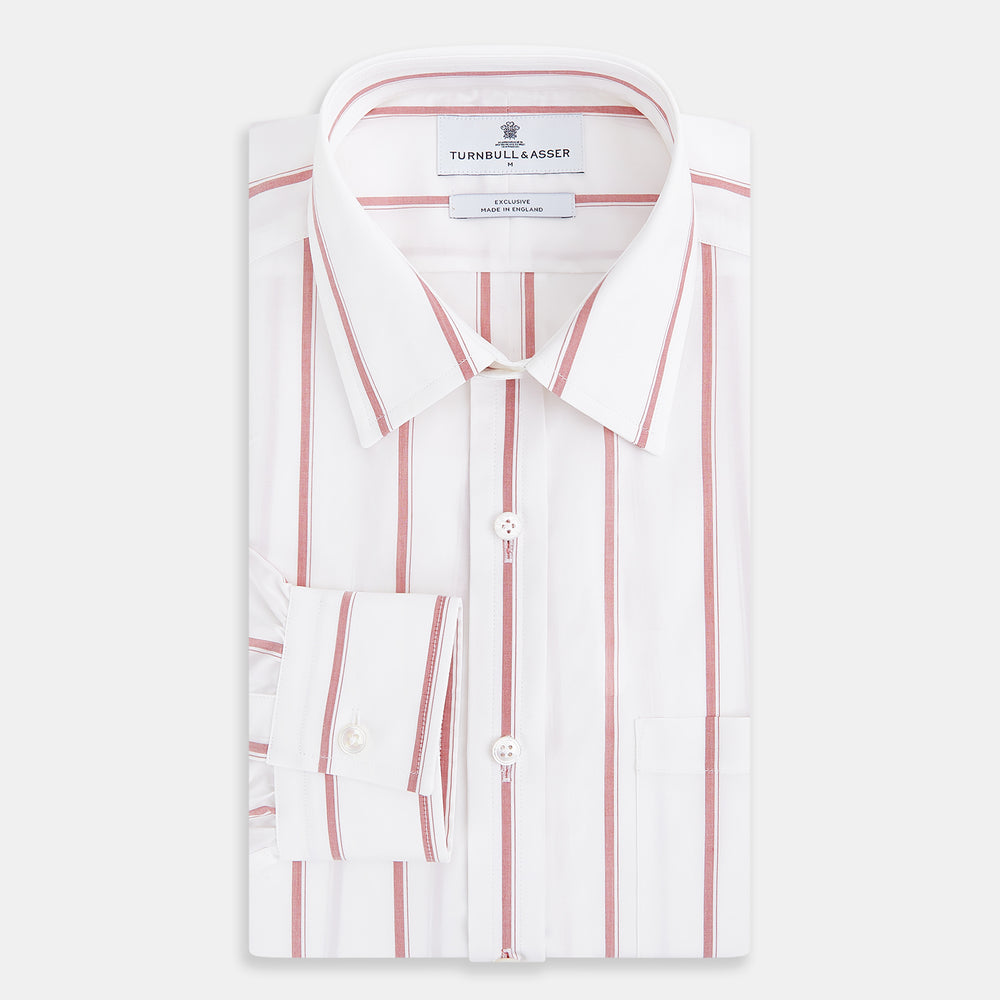 The Turnbull & Asser UK Track Striped Red on White Weekend Fit Shirt in Cotton features bold dark red stripes on a crisp white base, with long sleeves, a derby collar, front chest pocket, and buttoned cuffs, laid flat on a white background for a timeless men’s dress shirt aesthetic.