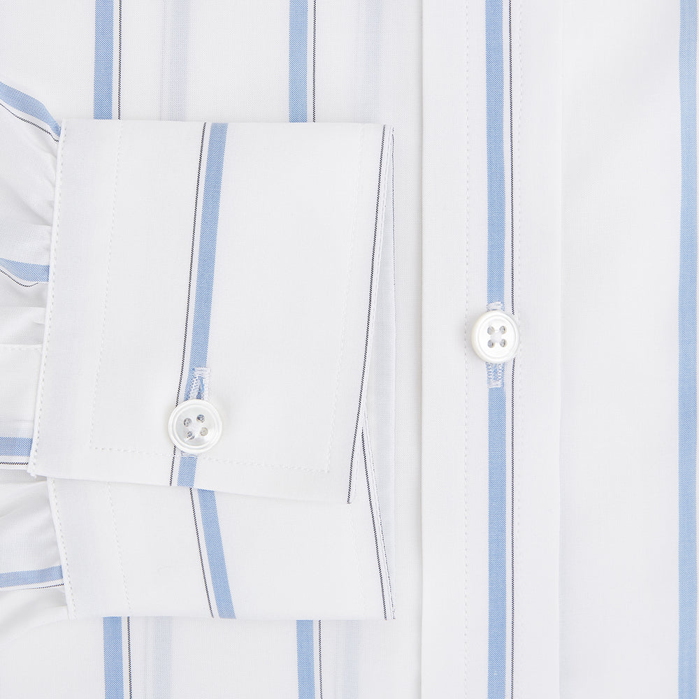 The Turnbull & Asser UK Track Striped Blue on White Weekend Fit Shirt in Cotton is a long-sleeve, button-up shirt featuring blue stripes on premium white Italian cotton, a Derby collar, and a chest pocket, elegantly laid flat against a white background.