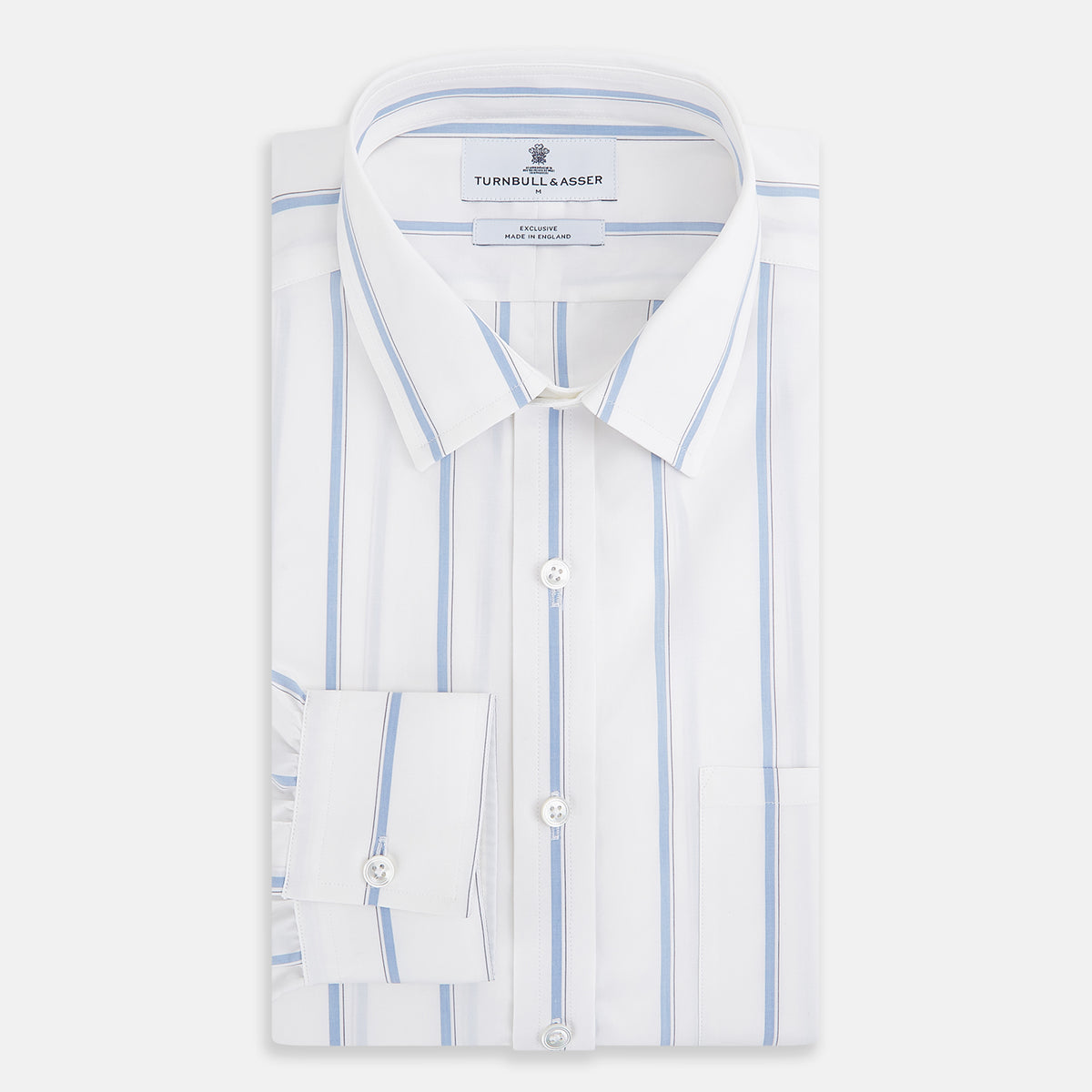 View 5 of product The Turnbull & Asser UK Track Striped Blue on White Weekend Fit Shirt in Cotton is a long-sleeve, button-up shirt featuring blue stripes on premium white Italian cotton, a Derby collar, and a chest pocket, elegantly laid flat against a white background.