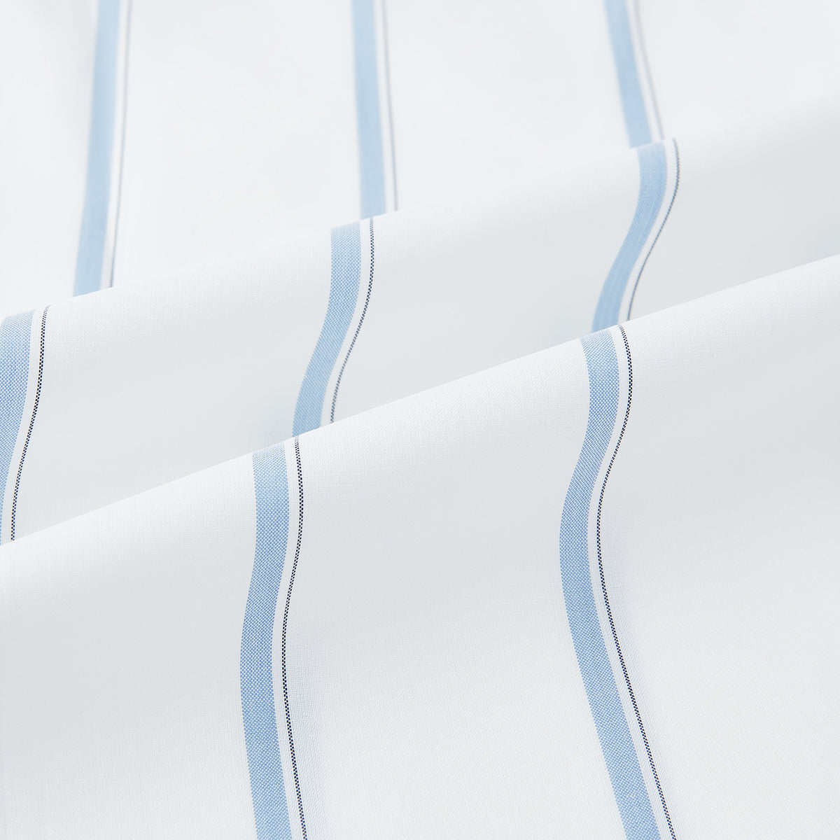 View 6 of product The Turnbull & Asser UK Track Striped Blue on White Weekend Fit Shirt in Cotton is a long-sleeve, button-up shirt featuring blue stripes on premium white Italian cotton, a Derby collar, and a chest pocket, elegantly laid flat against a white background.
