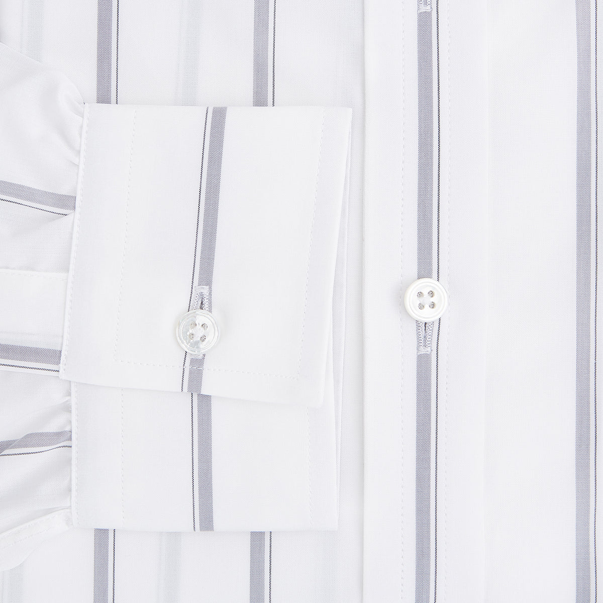 View 4 of product Introducing the Track Striped Grey on White Weekend Fit Shirt in Cotton by Turnbull & Asser UK—a men’s long-sleeve dress shirt crafted from crisp white cotton, featuring vertical grey stripes, a button-down front, derby collar, cuffs, and a chest pocket. The shirt is displayed laid flat on a white surface.