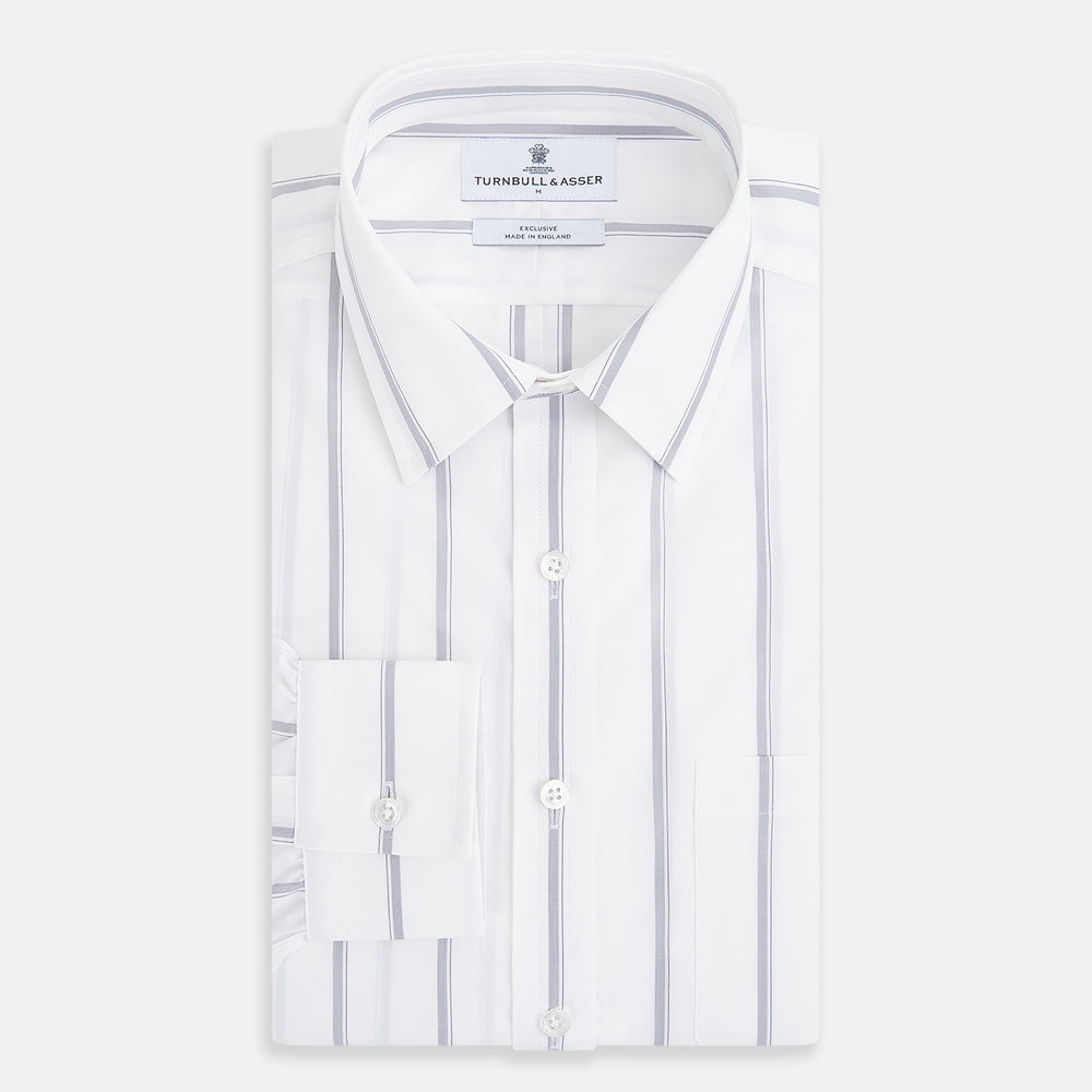 Introducing the Track Striped Grey on White Weekend Fit Shirt in Cotton by Turnbull & Asser UK—a men’s long-sleeve dress shirt crafted from crisp white cotton, featuring vertical grey stripes, a button-down front, derby collar, cuffs, and a chest pocket. The shirt is displayed laid flat on a white surface.